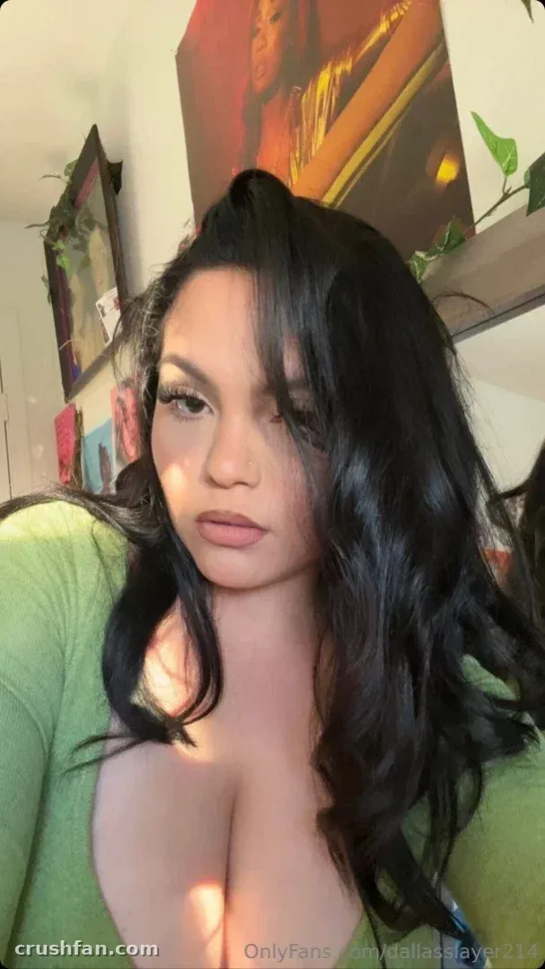 214 Dallas Slayer com cabelo longo escuro e top verde em ambiente interno
