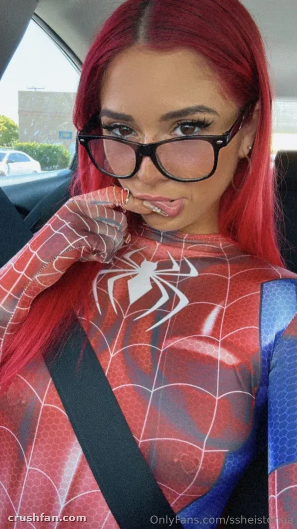 Toria Lorraine dans un body imprimé araignée rouge et bleu assise dans une voiture