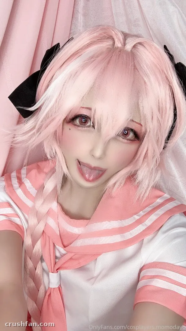 Creator in a pink wig and white sailor-style top with pink stripes against a pastel backdrop