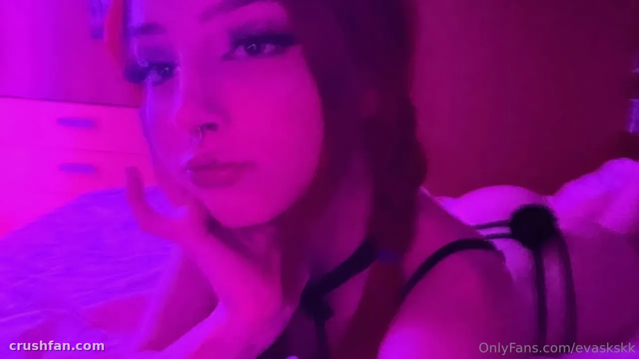 Eva Cappellini in magenta neon light, reclining and looking at the camera