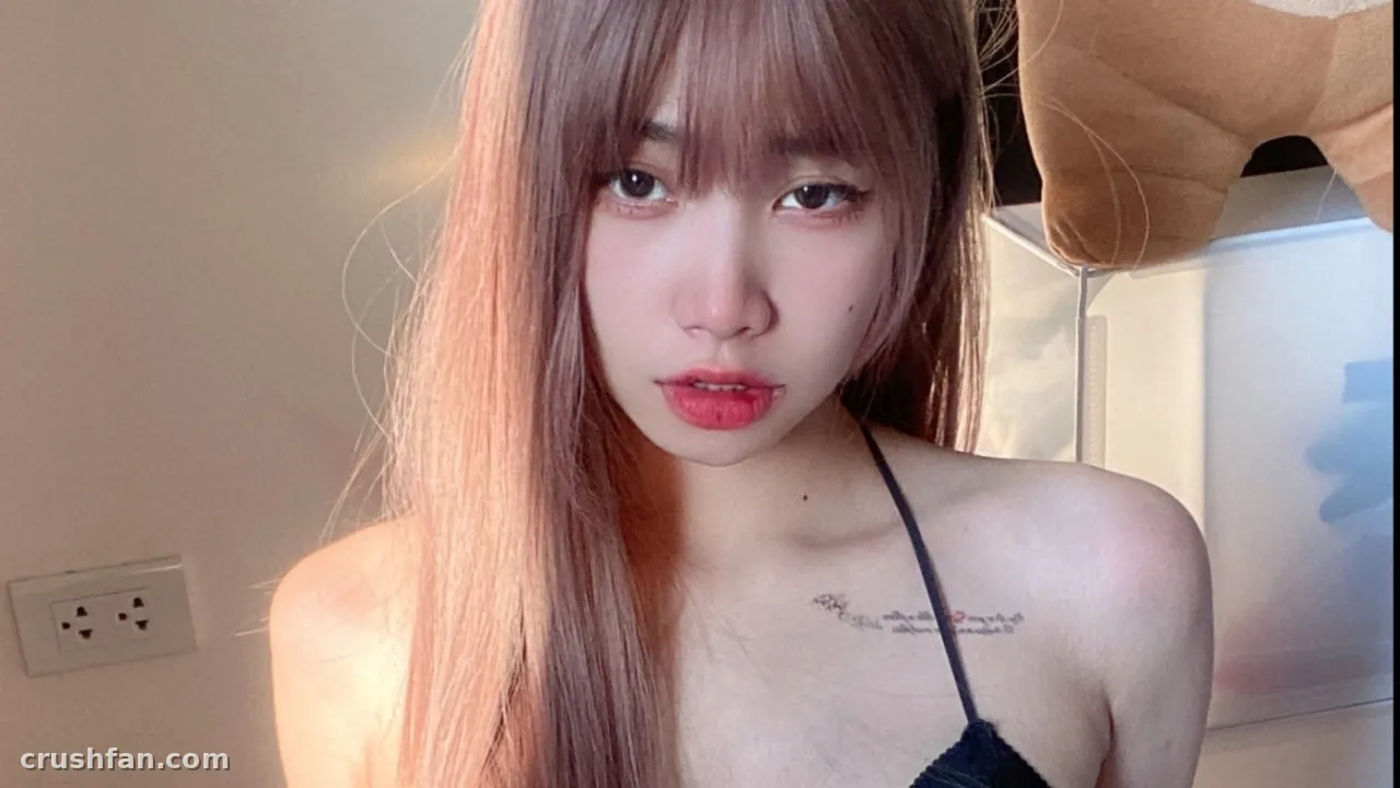 Close-up indoor portrait of a woman with long hair and bangs in a dark top