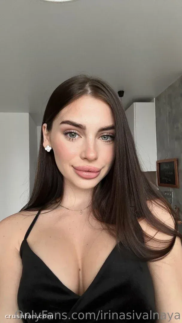 Criadora com um top preto posando em ambiente interno em um retrato próximo