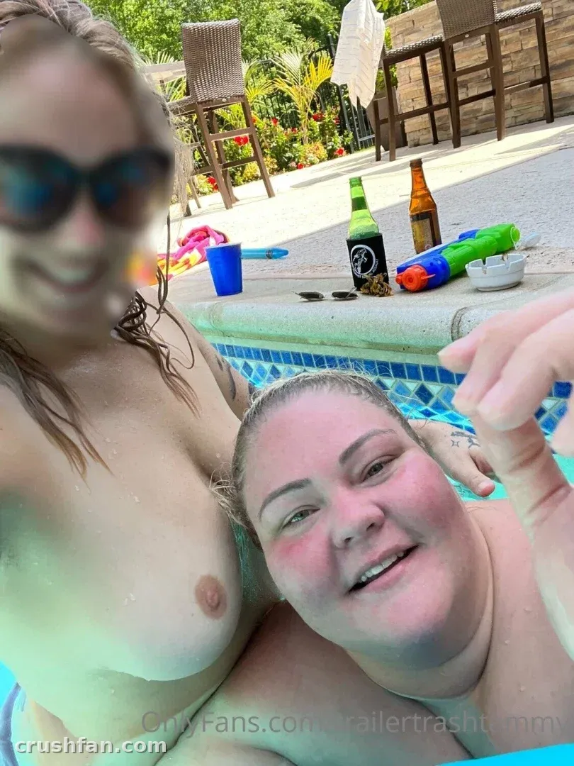 Chelcie Lynn in a pool wearing sunglasses with a bottle on the edge.