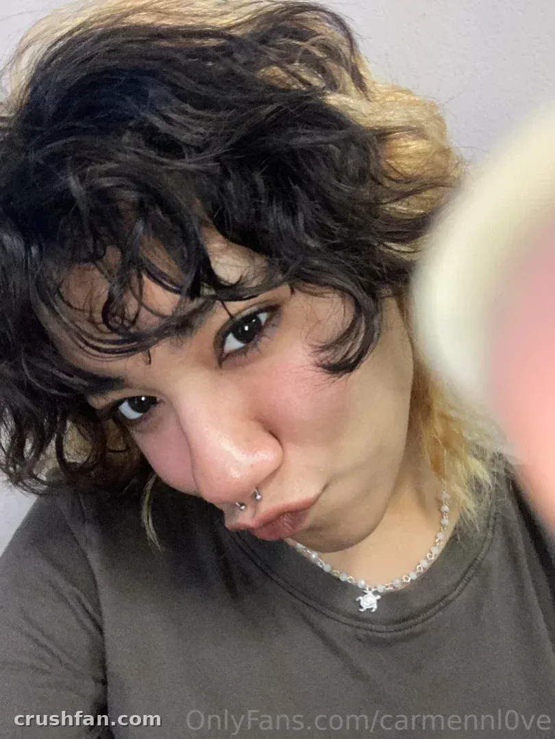 La oficial Carmen Love en una selfie en primer plano con un top gris y un collar de plata.