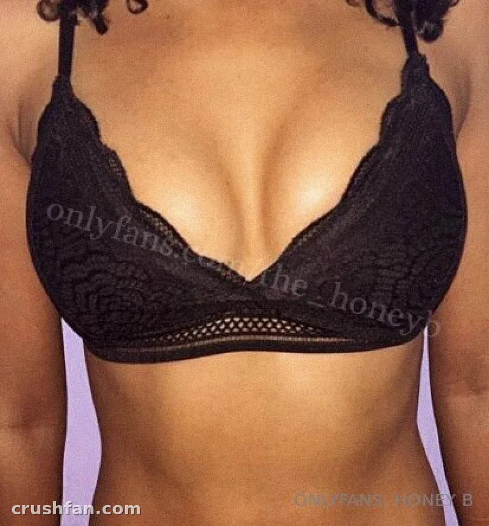 Primer plano de un bralette de encaje negro llevado por una creadora sobre un fondo claro