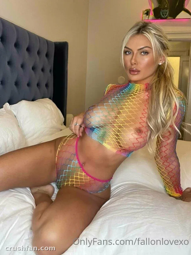 Fallon com um conjunto de tule arco-íris reclinada em uma cama com roupa de cama branca