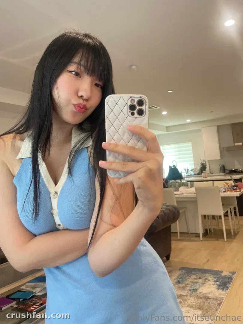 itseunchae in einem blauen Strickoberteil beim Spiegel-Selfie drinnen