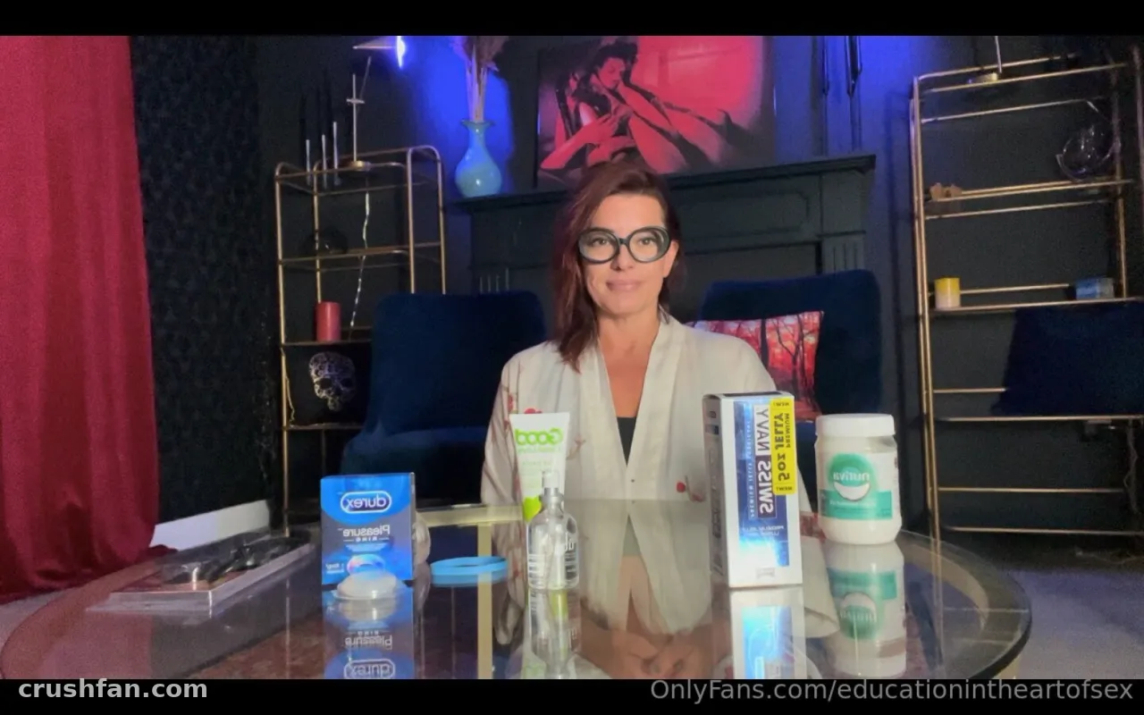 BC Madison Gulli, Clinical Sexologist seated at a glass table with products in a softly lit studio.