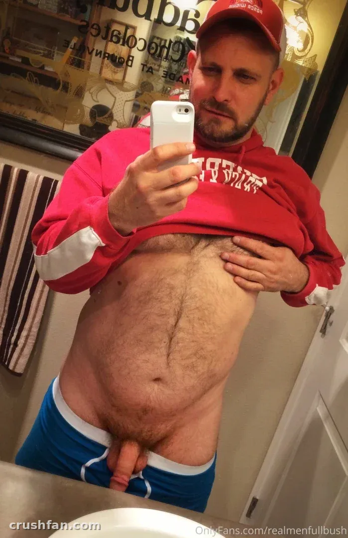 Seattle Dad en casquette et sweat à capuche rouges prenant un selfie miroir dans la salle de bain.