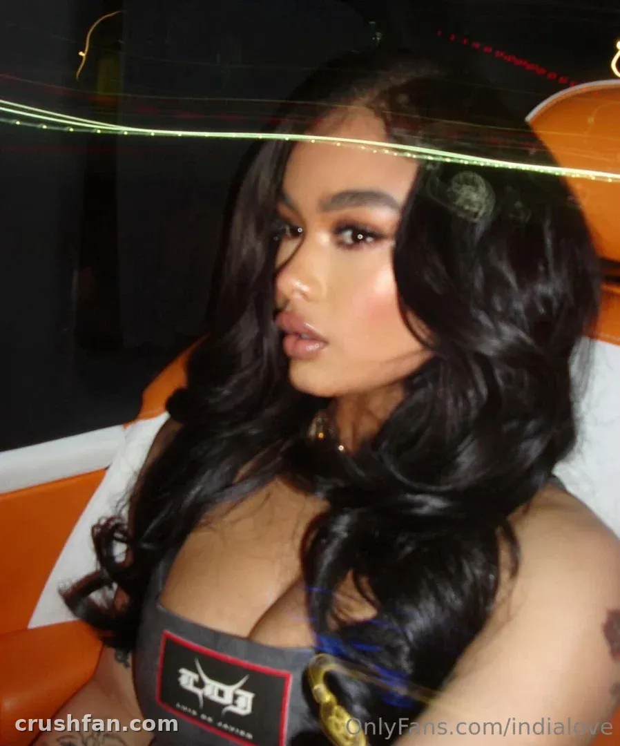 India Love in einem grauen Top mit langem dunklem welligem Haar, gedämpftes warmes Licht