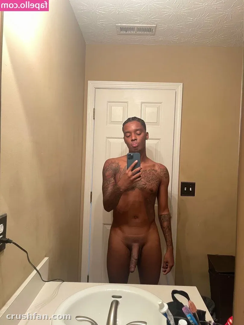 Creador tomándose una selfie frente al espejo en un baño con paredes beige y una puerta blanca