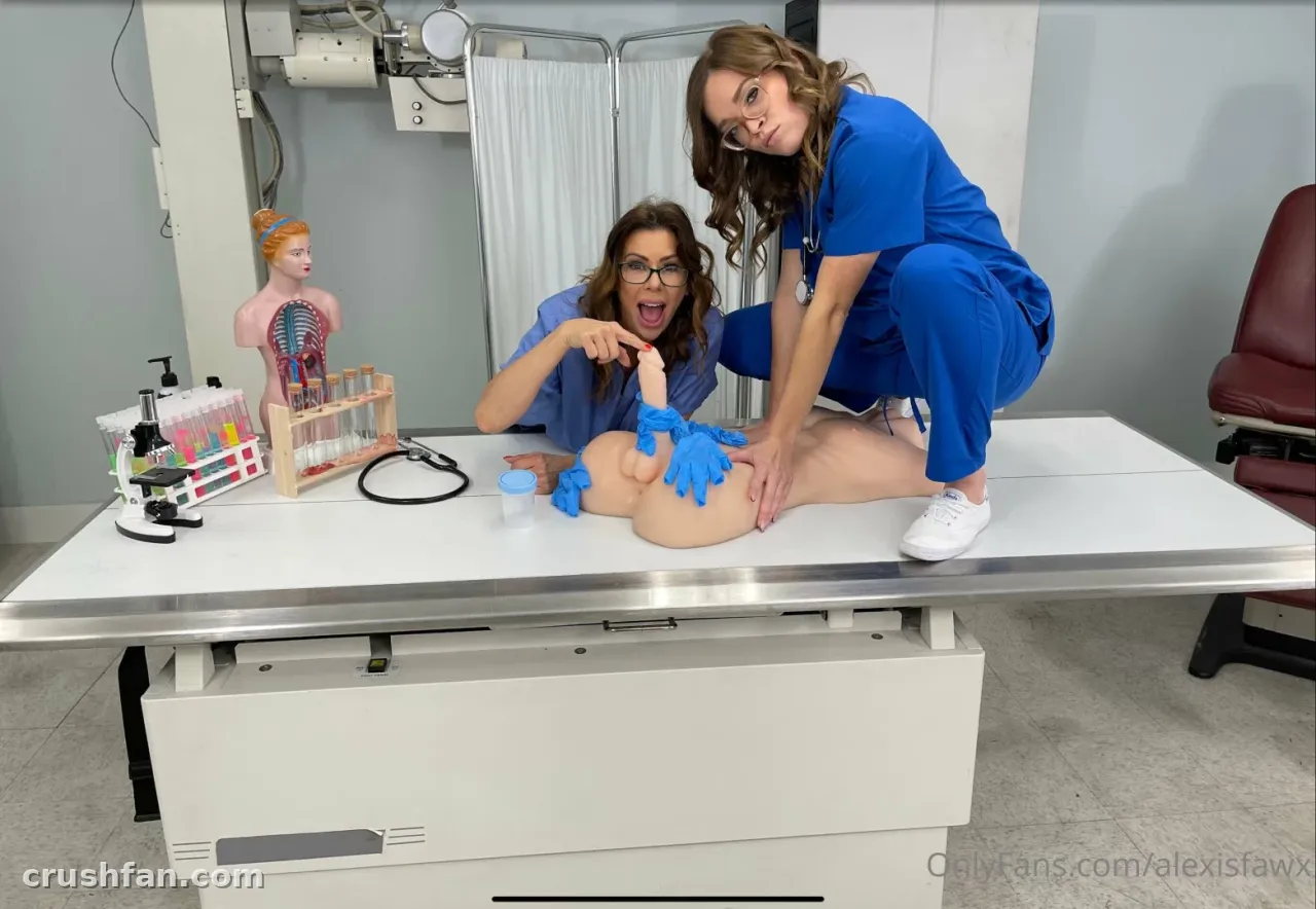 Alexis Fawx de scrubs azuis agachada em uma mesa de exame branca em uma cena médica divertida.