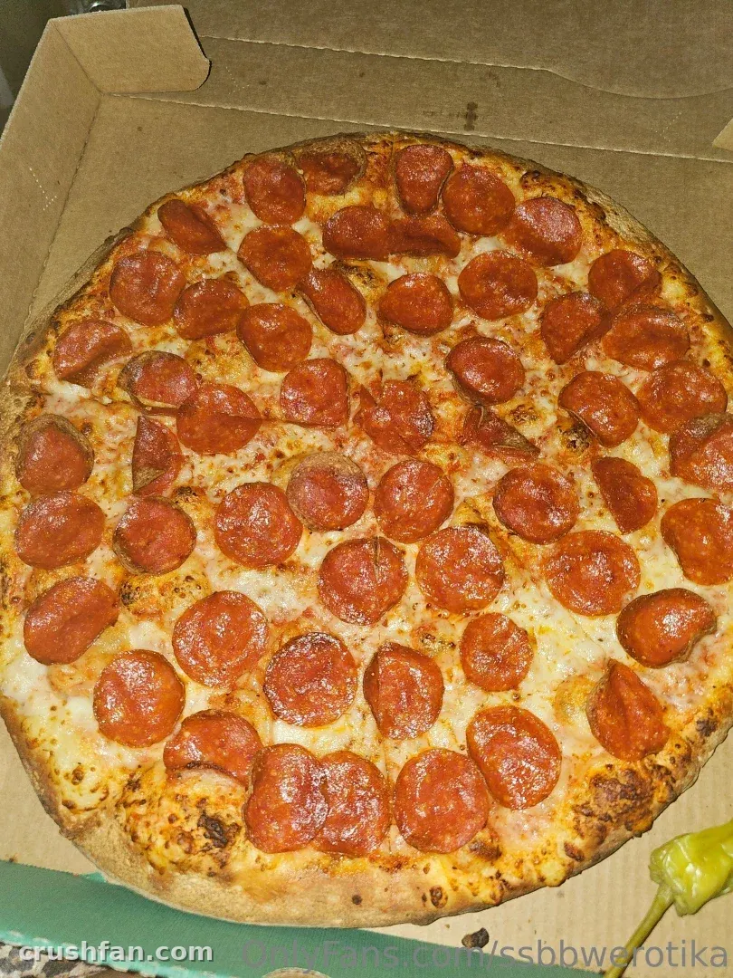 Erotika shows a whole pepperoni pizza inside an open cardboard takeaway box.