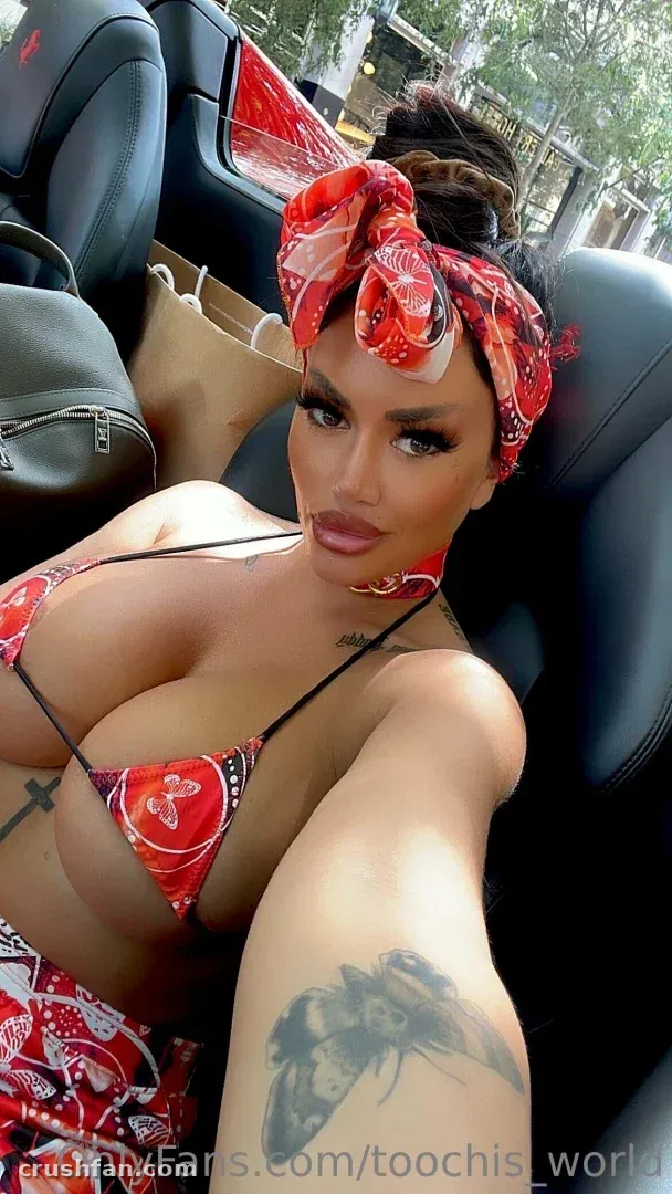 Toochi Kash in a red patterned bikini and headscarf sitting in a car