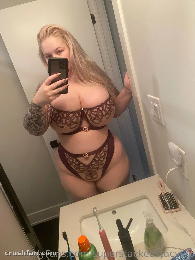 Stacy en lingerie en dentelle bordeaux prenant un selfie miroir dans une salle de bain