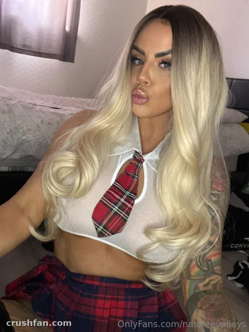 Natalee Harris dans un crop top blanc et une cravate à carreaux à l'intérieur