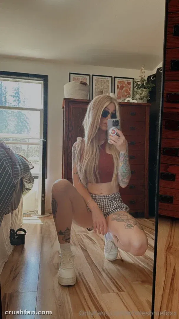 Wholesome Fox tirando uma selfie no espelho em ambiente interno com roupa casual