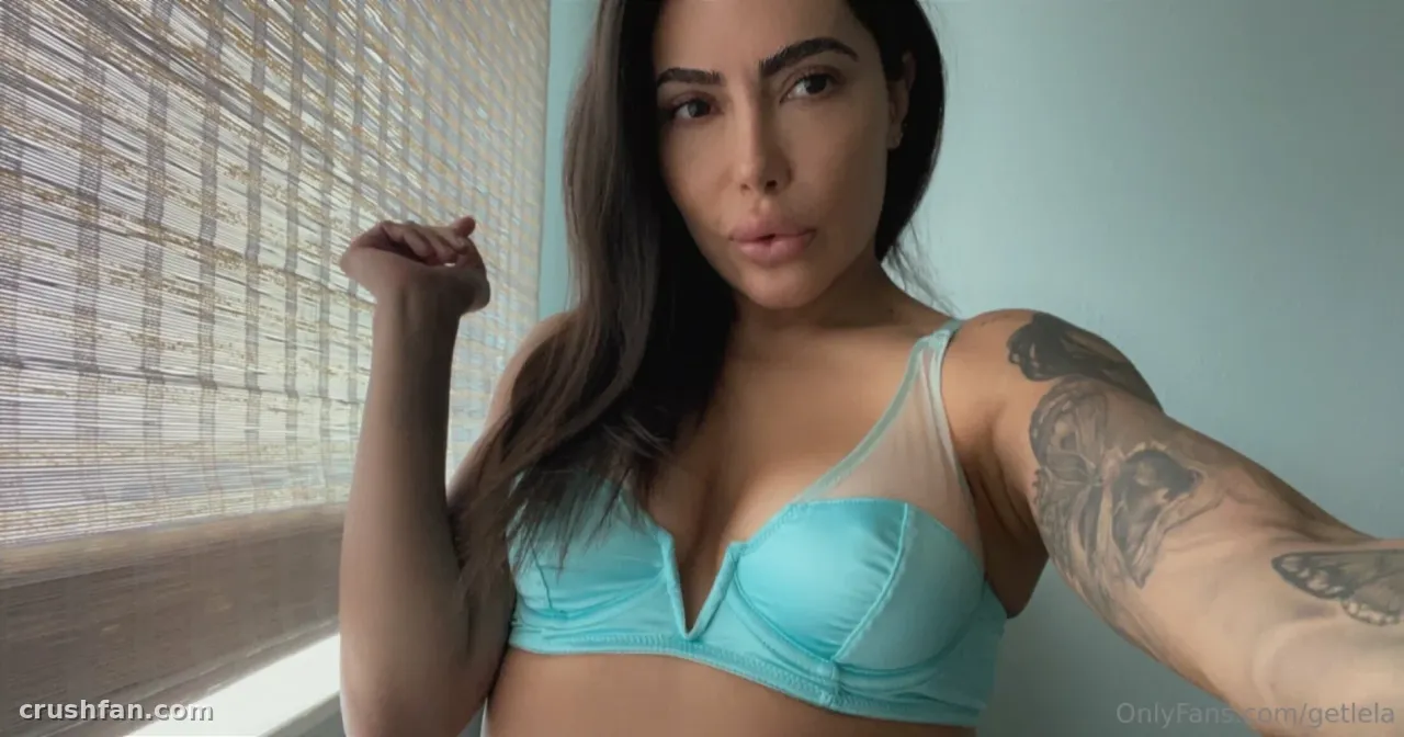 Créatrice en bralette turquoise posant près d'un store en bambou dans une douce lumière du jour