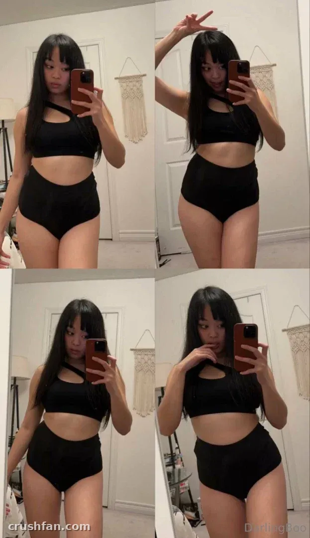 Criadora com um conjunto preto de duas peças tirando selfies no espelho em um ambiente claro