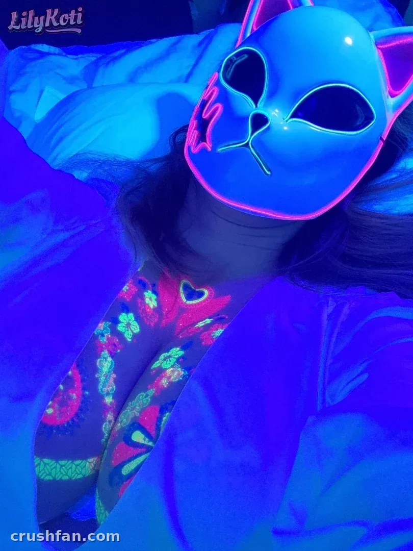 LilyKoti portant un masque de chat éclairé au néon dans une lumière bleue et rose