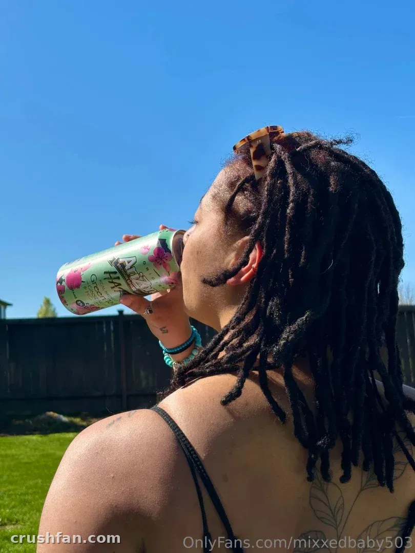 Creator im Profil, die draußen unter klarem blauem Himmel aus einer Dose trinkt