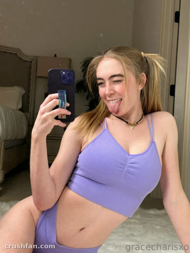 Grace Charis taking a mirror selfie in a lilac lounge set indoors