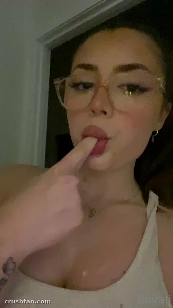 Nahaufnahme-Selfie einer Frau mit klarer Brille und einem Finger nahe ihren Lippen
