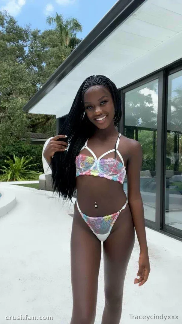 Traceycindyxxx in einem bunten Bikini auf einer sonnigen Außenterrasse