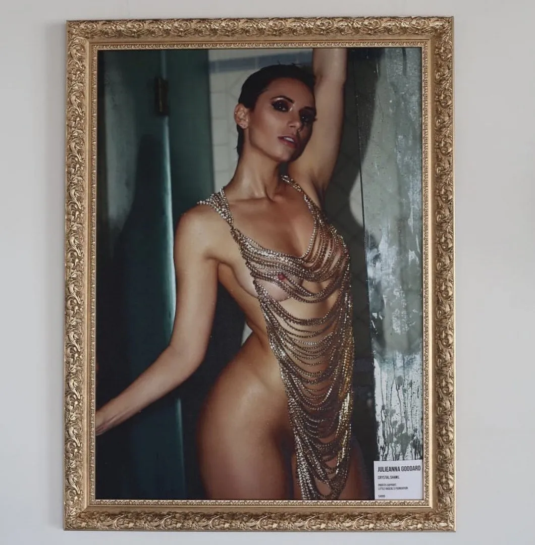 Framed portrait of Yesjulz wearing layered chain jewellery against a textured green background.