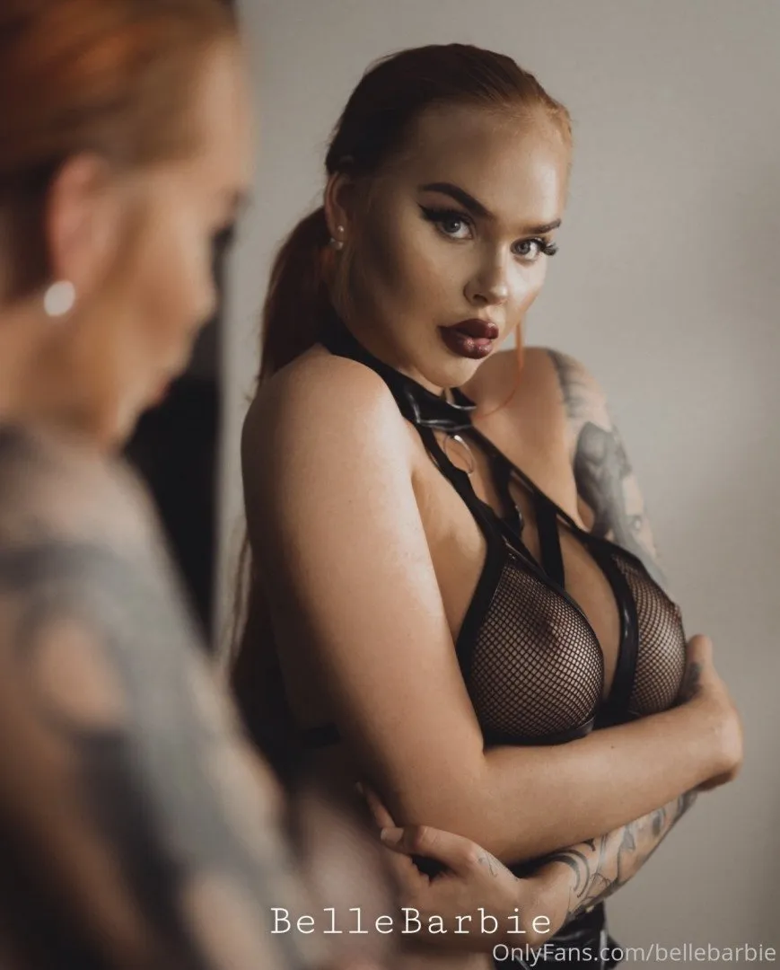 Bellebarbie com um top de tule preto posando em frente a um espelho