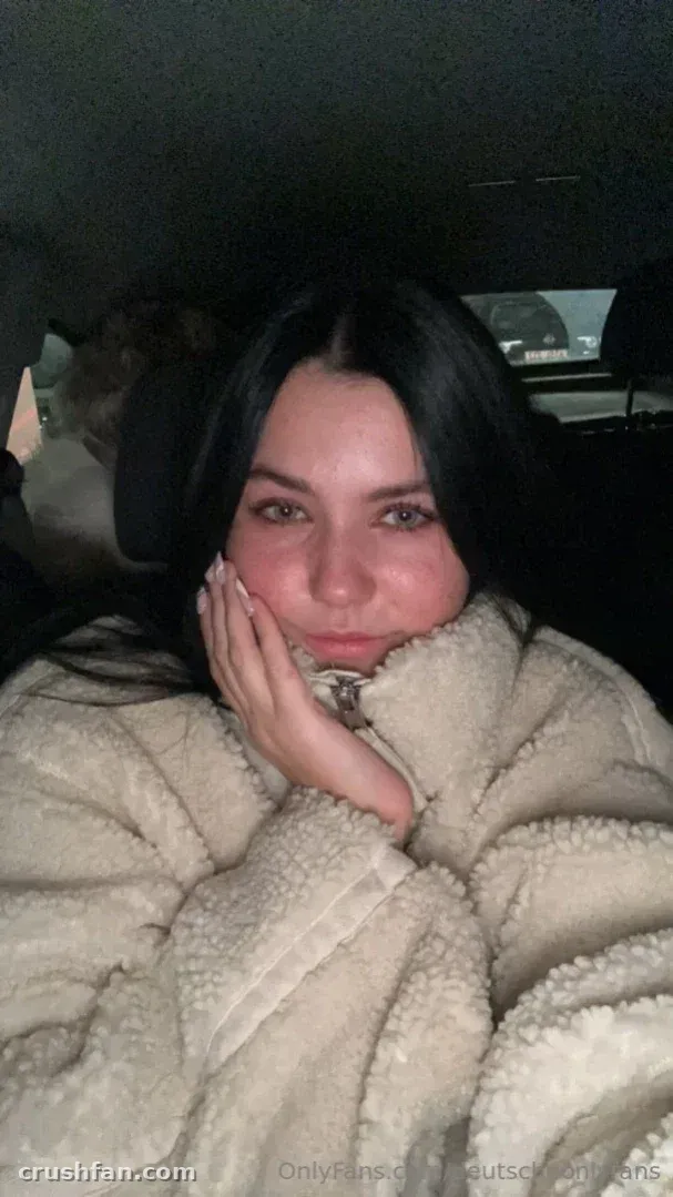 Deutsche Onlyfans con una chaqueta esponjosa color crema tomándose un selfie nocturno en el coche