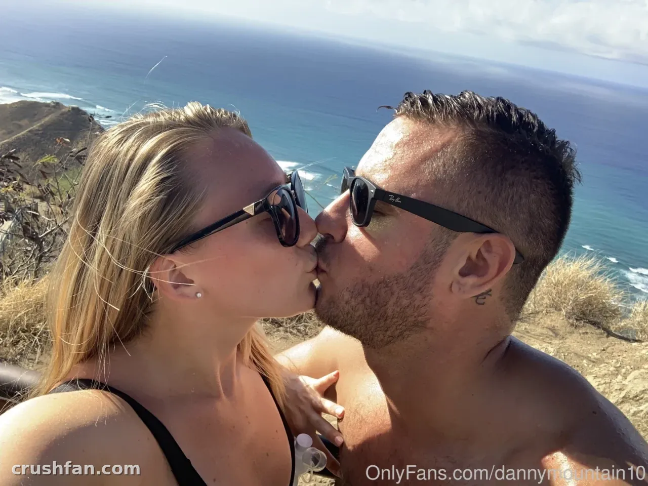 Danny Mountain küsst eine Frau im Freien am Meer bei hellem Sonnenlicht