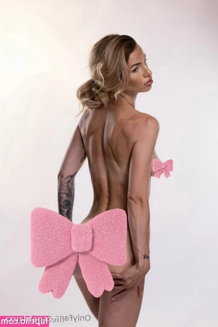 Marssy with a large pink bow prop in a bright studio setting