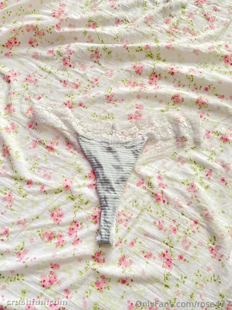 Bragas de rayas sobre ropa de cama blanca floral con luz diurna suave