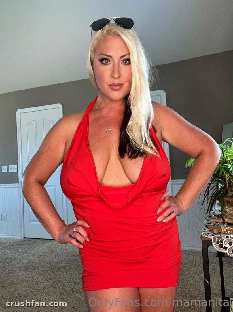 Nita Marie XXX in a red halter dress standing indoors with sunglasses on her head