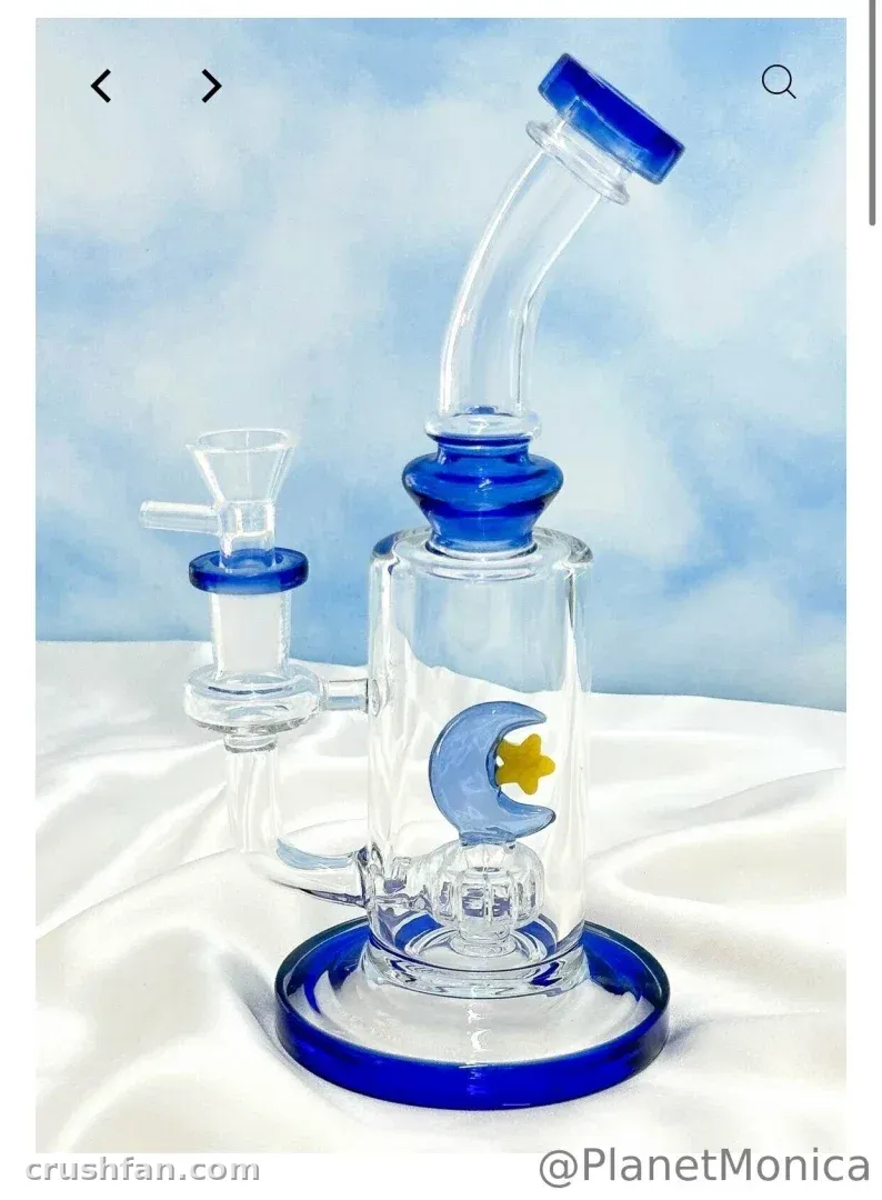 Clear glass water pipe with blue accents and a moon design on white fabric against a blue background