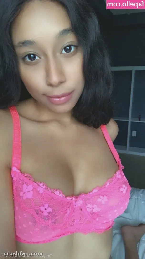 Creator in a pink lace bralette posing indoors in a close-up portrait