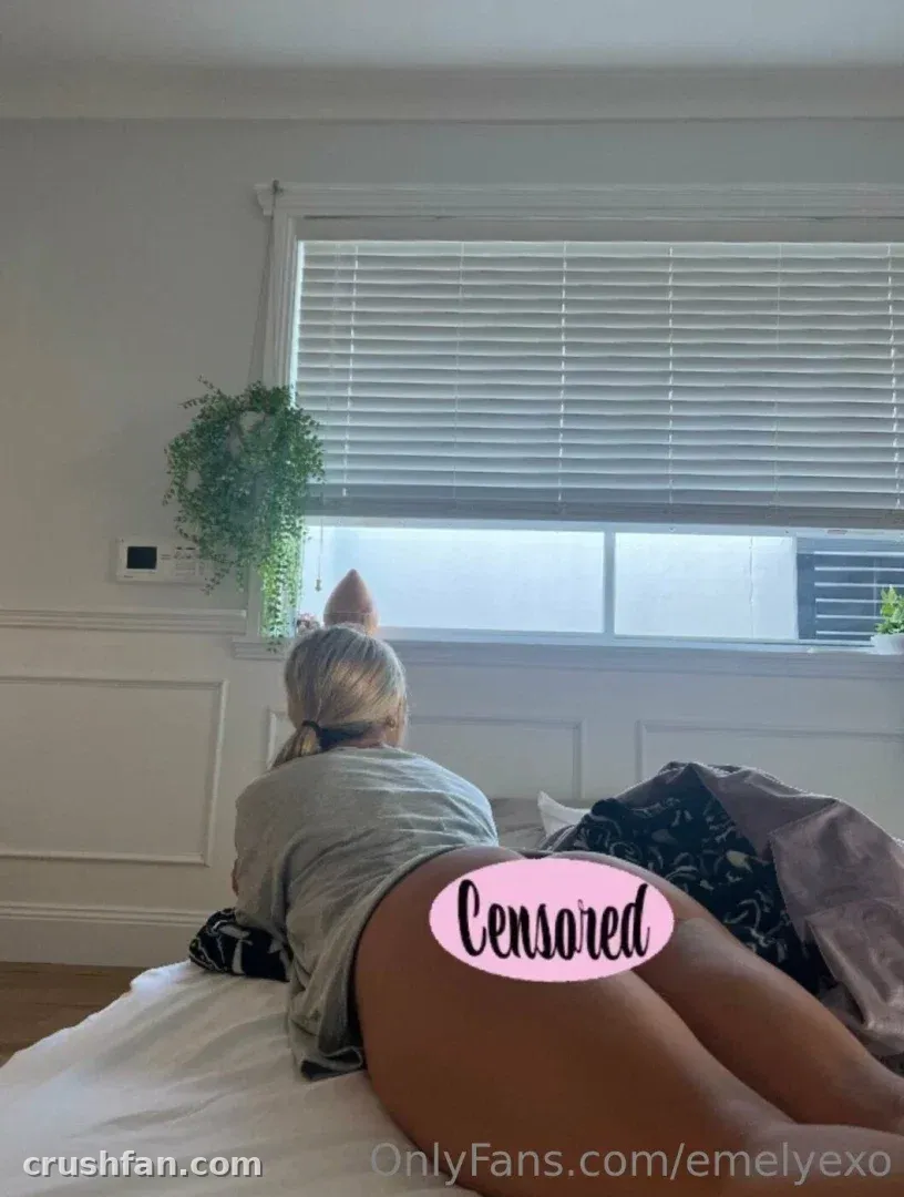 Em deitada em uma cama em um quarto claro com uma janela e uma planta pendurada