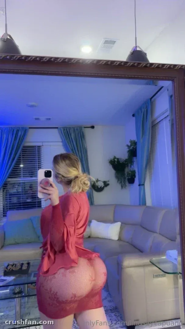 Lindsay Capuano con un vestido rojo tomándose una selfie en el espejo en una sala de estar