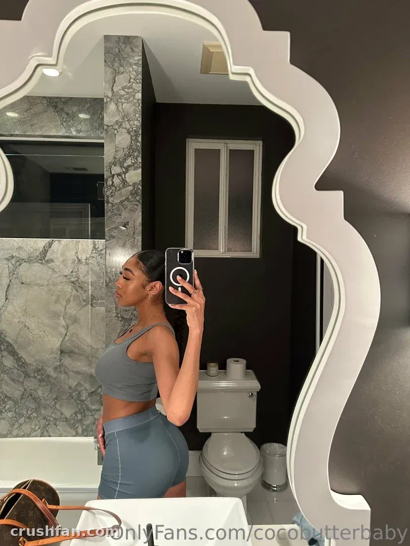 Yara taking a mirror selfie in a bathroom wearing a grey two-piece set.