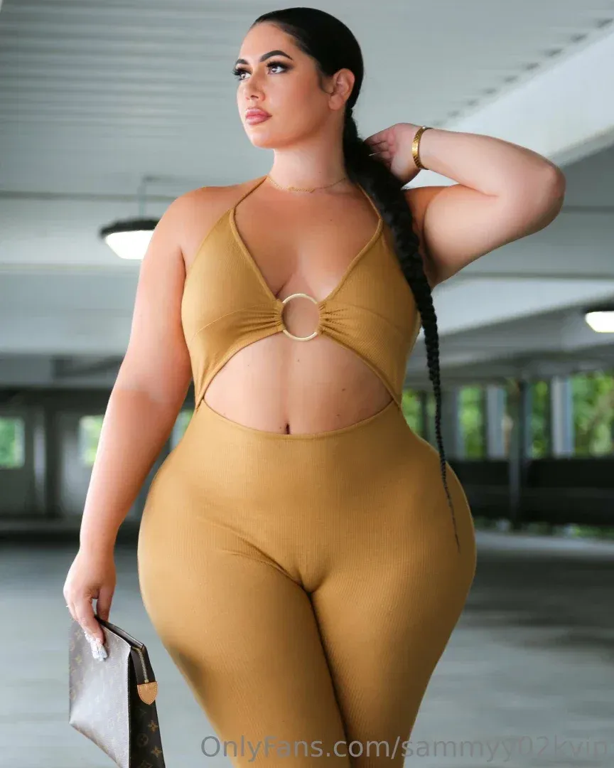 Sammyy02k dans un body échancré couleur moutarde et un legging posant dans une aire de stationnement