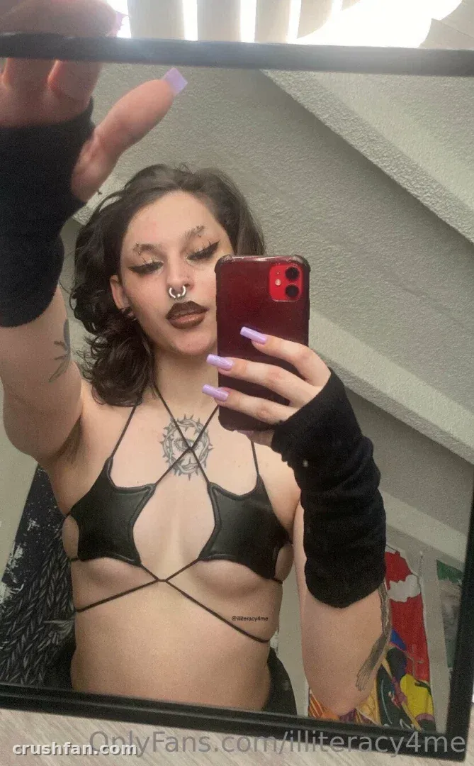 Alice prend un selfie miroir en portant un haut noir à lanières et des mitaines.