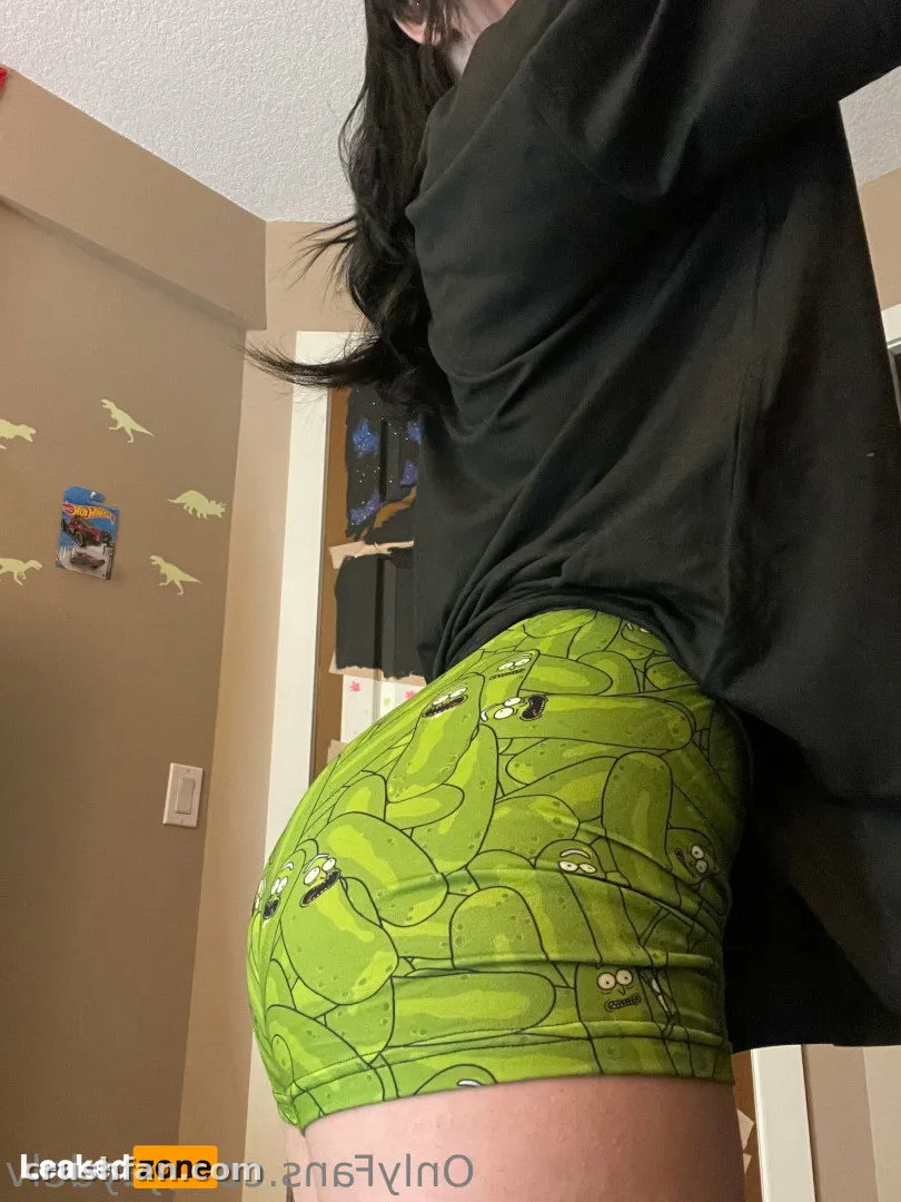 Jayde in a black top and bright green patterned shorts taking an indoor mirror selfie