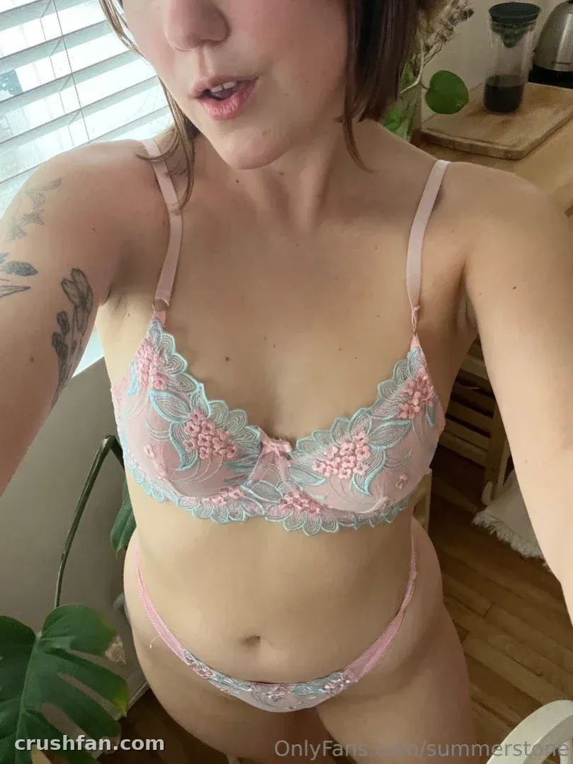 Femme en lingerie en dentelle rose et menthe prenant un selfie rapproché à l'intérieur