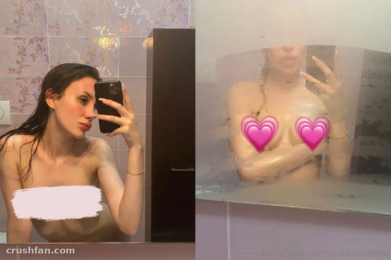 Julia Voss tirando uma selfie no espelho em um banheiro azulejado com o cabelo molhado