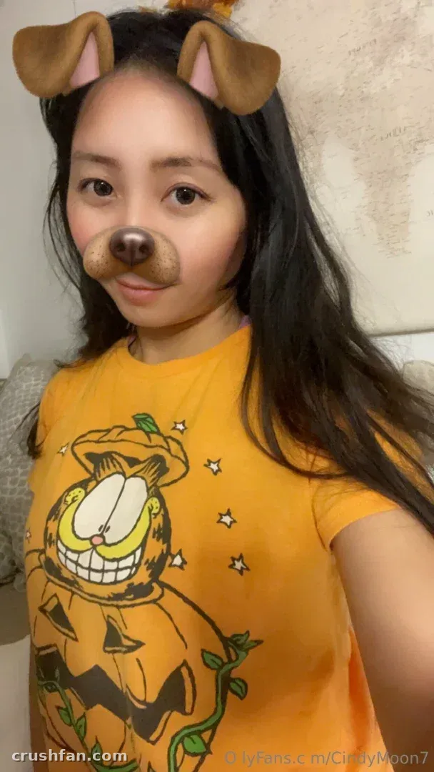 Cindy Moon in an orange cartoon-print shirt wearing a playful dog filter