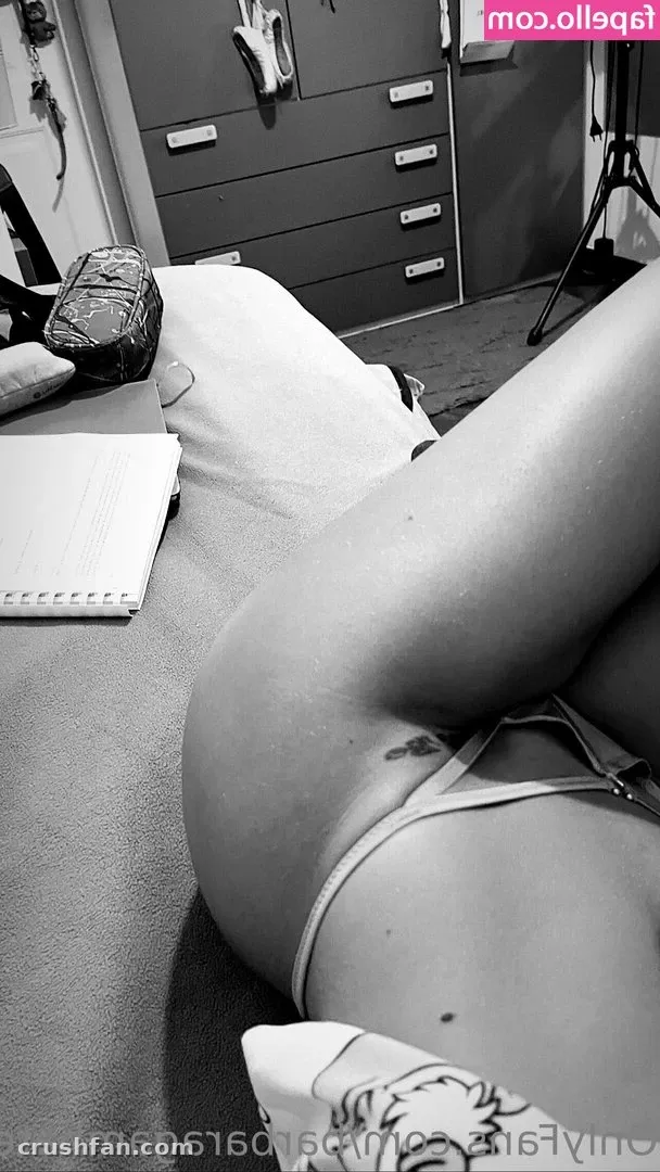 Black and white indoor photo of Barbara Gambatesa resting on a light surface near a chest of drawers