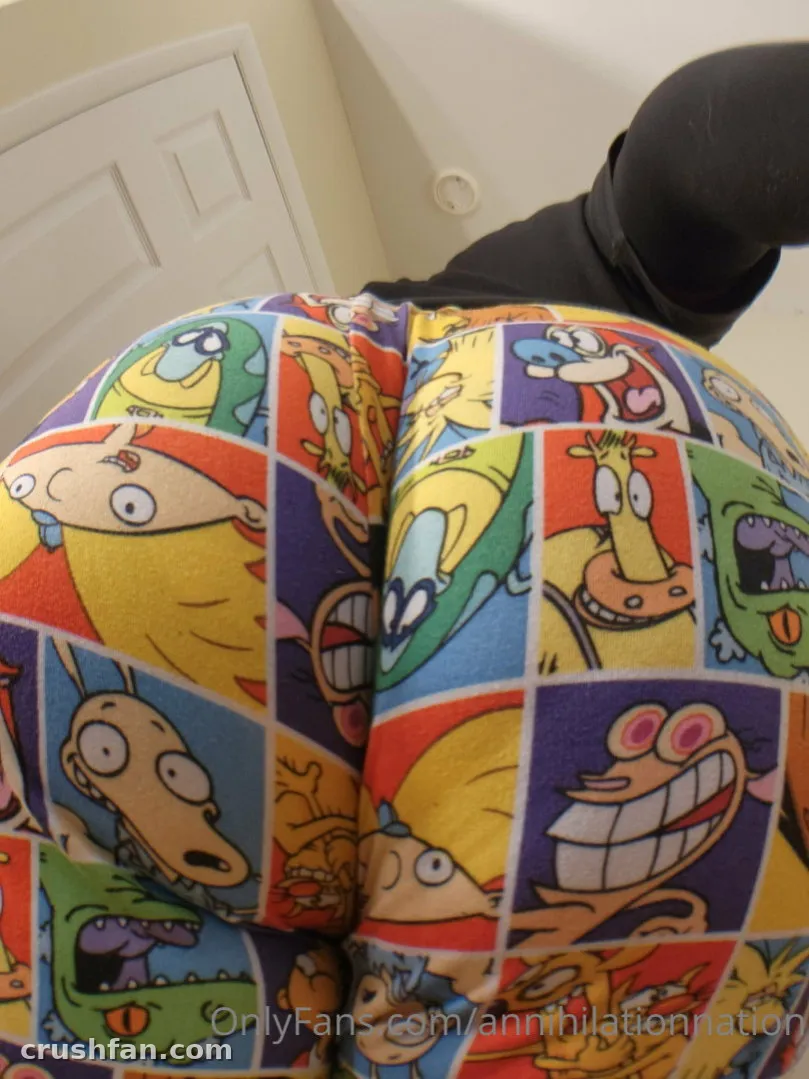 Creator in colourful cartoon-print leggings seen from behind in an indoor low-angle shot