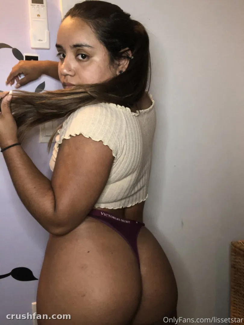 Creator in a cream crop top and plum bottoms posing indoors against a plain wall