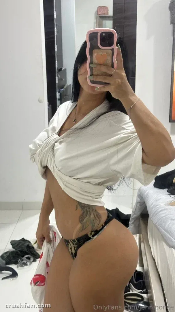 Mirror selfie of a woman in a white gathered top and dark bottoms in a bright room